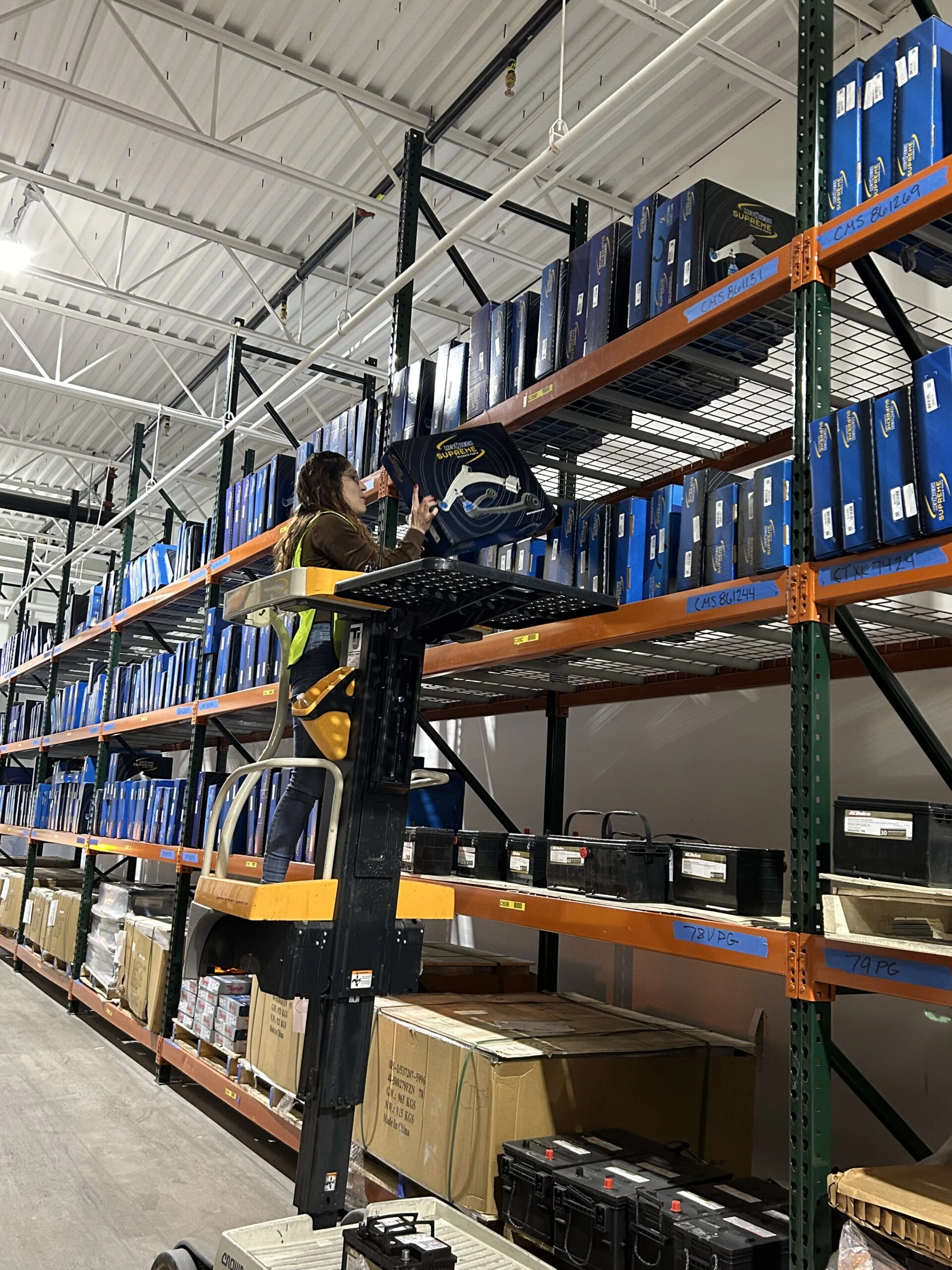Employee scanning auto parts on inventory rack in United Auto Supply Distribution Center in Rotterdam.